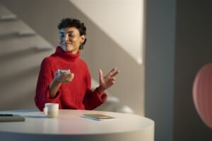 Femme souriante tenant son téléphone, appareils auditifs connectés